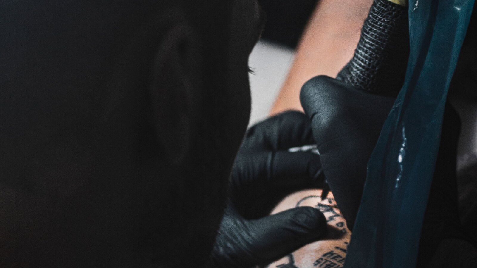 Artist tattooing an arm in the studio